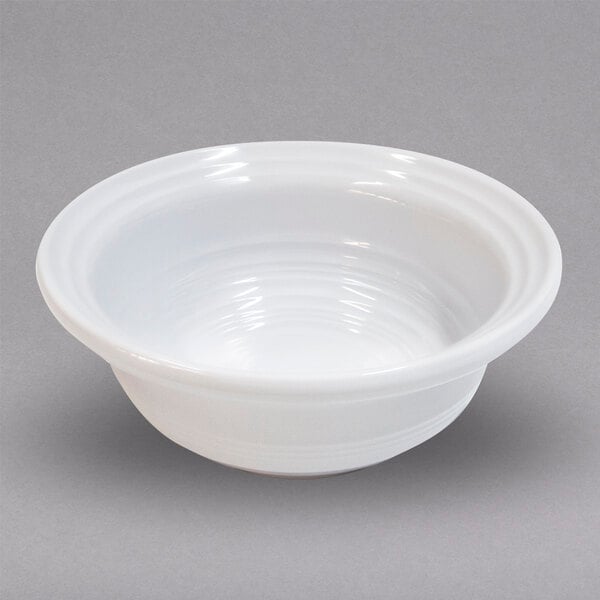 An Elite Global Solutions white melamine bowl with a swirled edge.