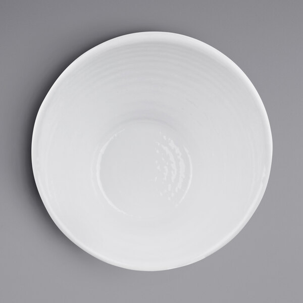 An Elite Global Solutions white melamine bowl on a gray background.