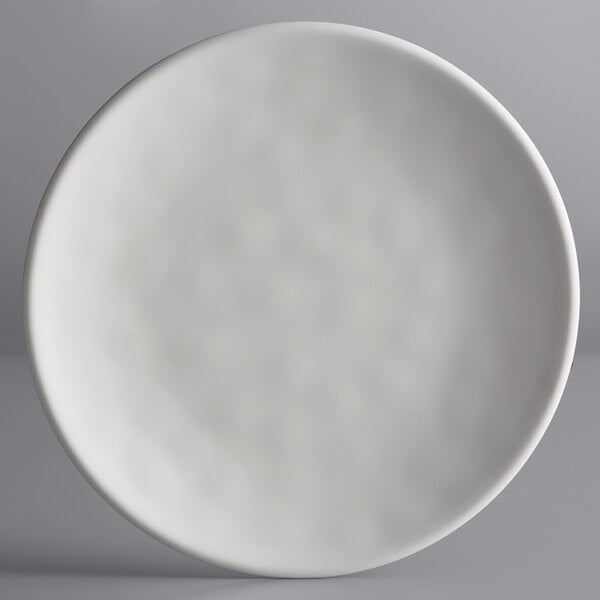 An Elite Global Solutions off white melamine plate with a circular design on it.