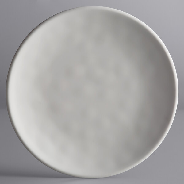 An Elite Global Solutions off white melamine plate with a small amount of food on it.