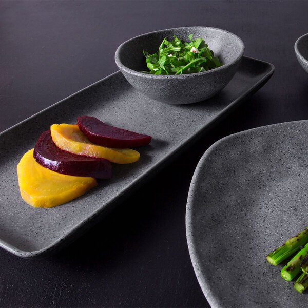 A rectangular granite stone melamine plate with asparagus, greens, and vegetables.