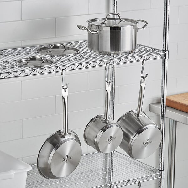 A metal rack with Vigor SS1 Series stainless steel pots and pans on it.