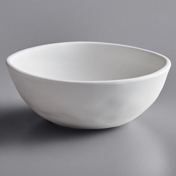 An Elite Global Solutions Tenaya off white melamine bowl on a gray surface.