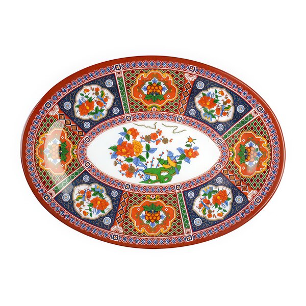 A close-up of a colorful Thunder Group Peacock oval platter with floral designs.