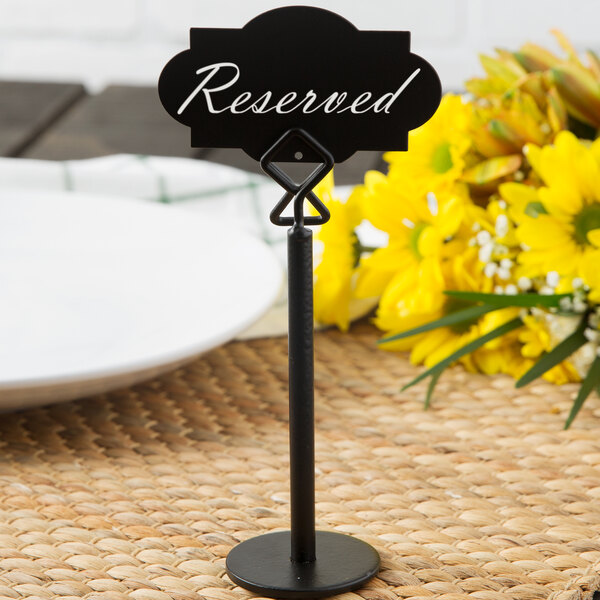 A black Tablecraft chalkboard label clipped to a table.