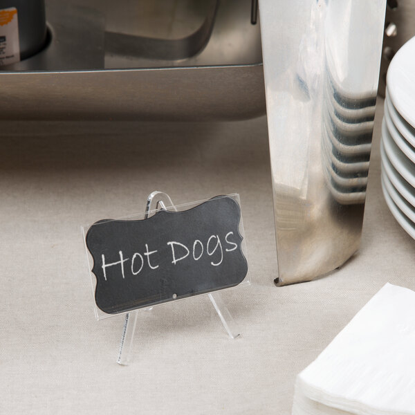 A Tablecraft marquee chalkboard label in white on a table with food.