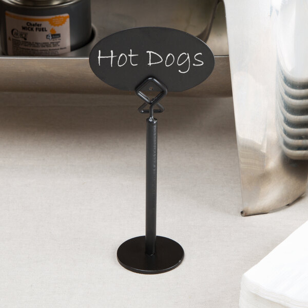 A black metal Tablecraft menu card holder on a counter with a sign.