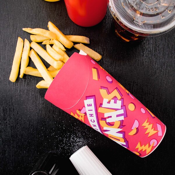 A Solo paper container of french fries and a drink on a table.