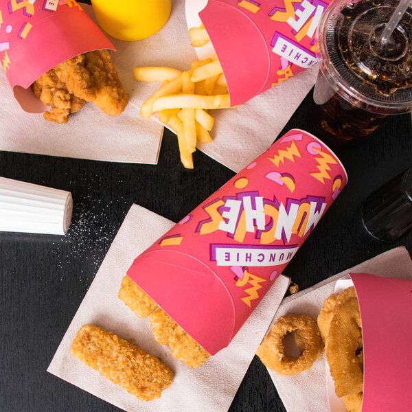 A Solo paper container on a table filled with chicken tenders and fries.