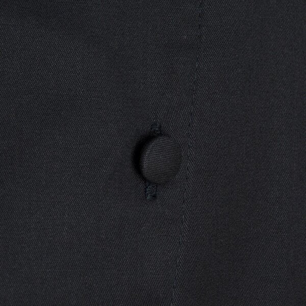 The back of a black Chef Revival chef coat with buttons.