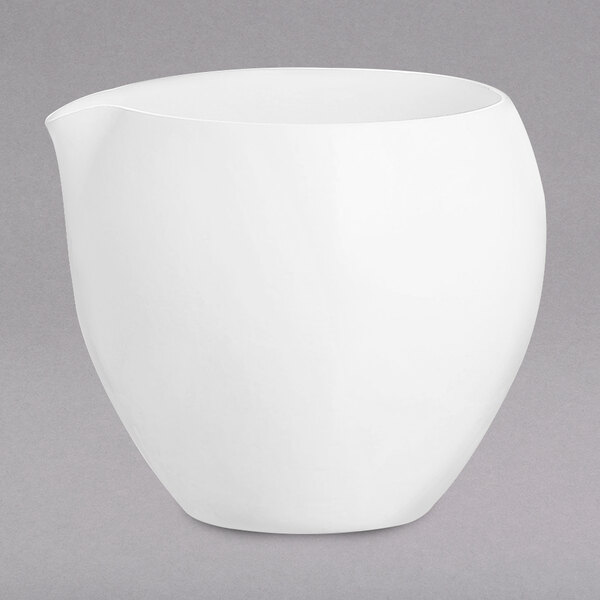 A white Chef & Sommelier bone china creamer with a lid on a gray surface.
