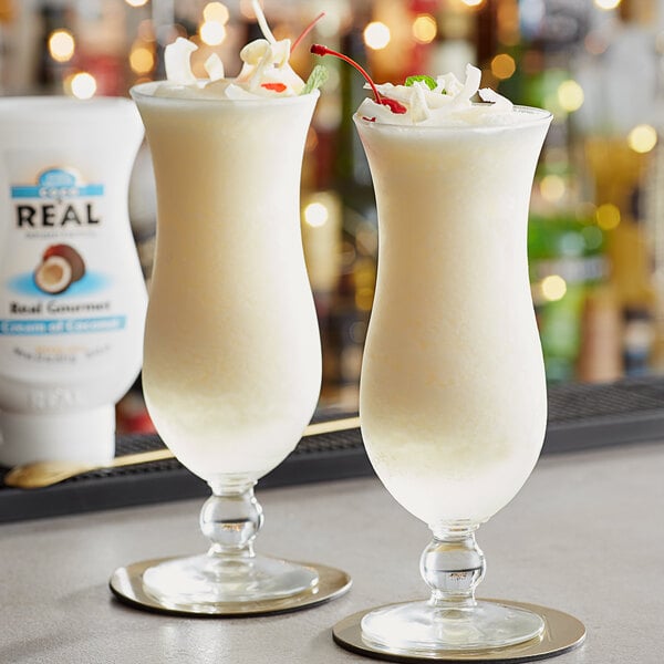 Two pina colada cocktails in a glass