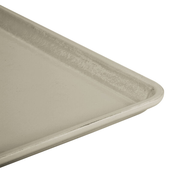A close-up of a Cambro desert rain fiberglass dietary tray with a white surface and a handle.