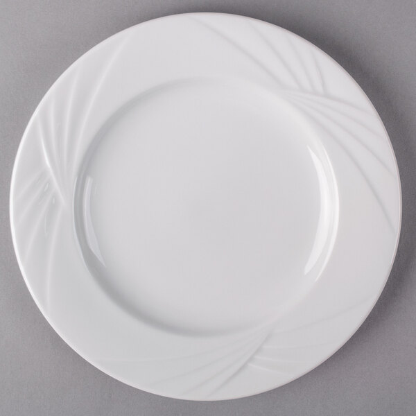 An Arcoroc white porcelain salad plate with a wavy design.