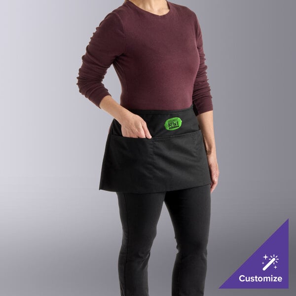 A kelly green poly-cotton waist apron with three pockets, worn by a person and customizable, measuring 12 by 24 inches.