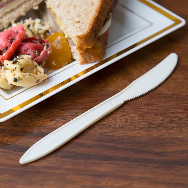 A white plate with food and a 6 3/8" medium weight cornstarch knife.