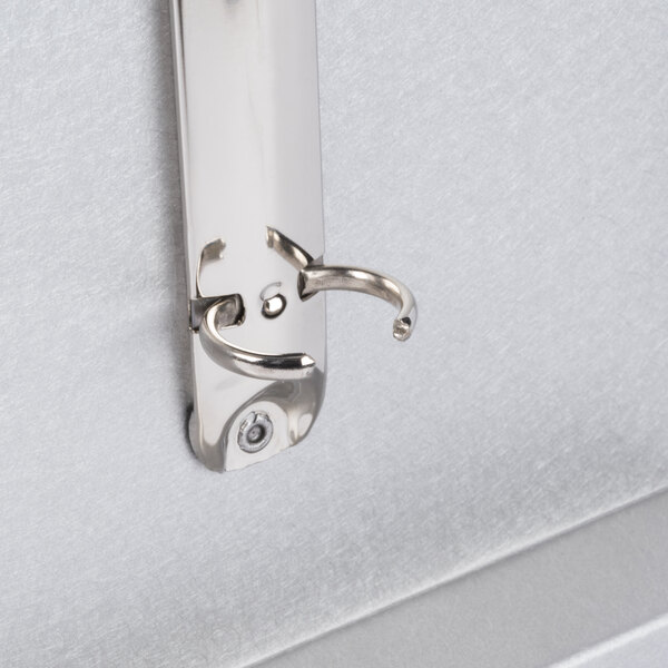 A Menu Solutions Alumitique aluminum menu tent on a metal wall hook.