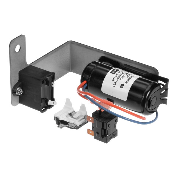 A black metal bracket holding a small black cylinder with wires on a SureShot Solutions capacitor.