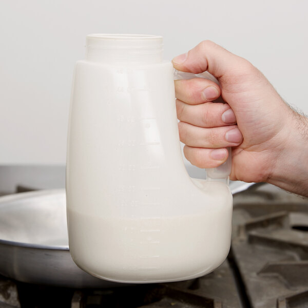 A hand holding a Tablecraft PP48J 48 oz. dispenser jar.