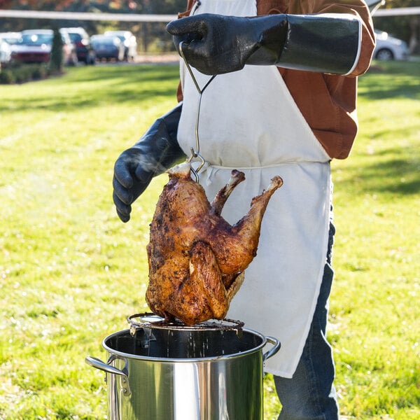 Pulling a deep-fried turkey out of a turkey fryer.