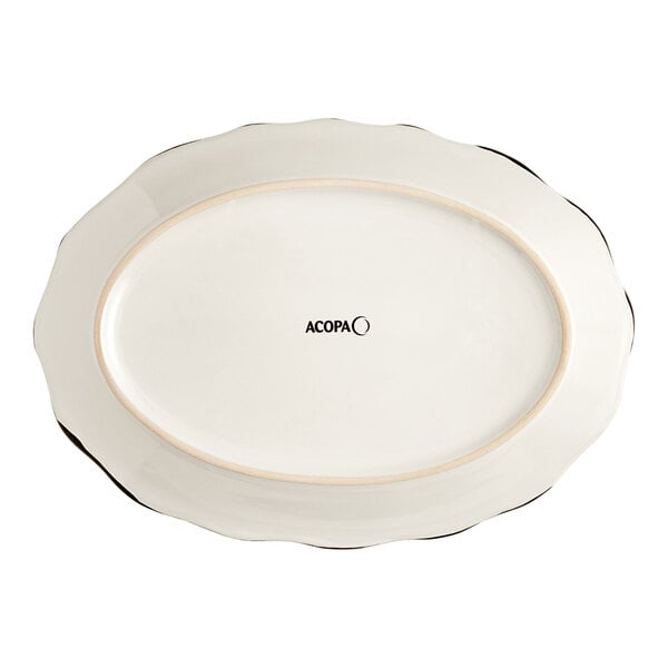 An ivory stoneware oval platter with a scalloped edge and black trim.