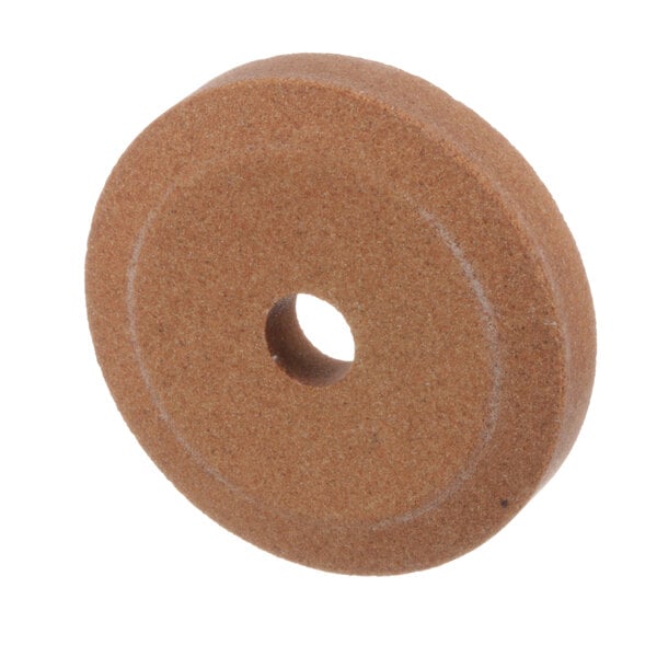 A brown circular grinding stone with a hole in the center.