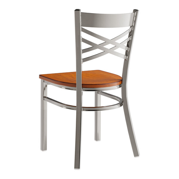 A Lancaster Table & Seating metal cross back chair with a wood seat and back.