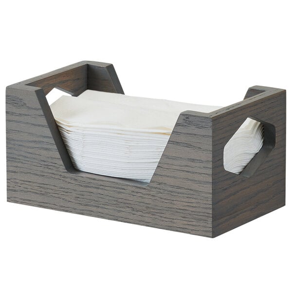 A Cal-Mil Ashwood gray oak wood napkin holder with white napkins inside.