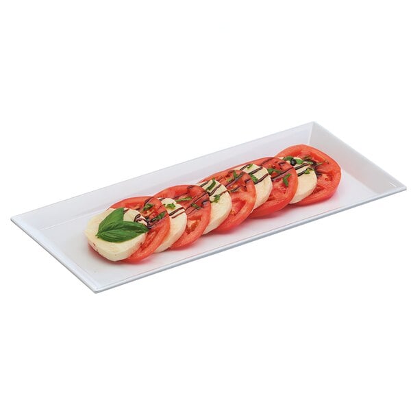 A rectangular white melamine tray with sliced tomatoes, mozzarella, and basil.