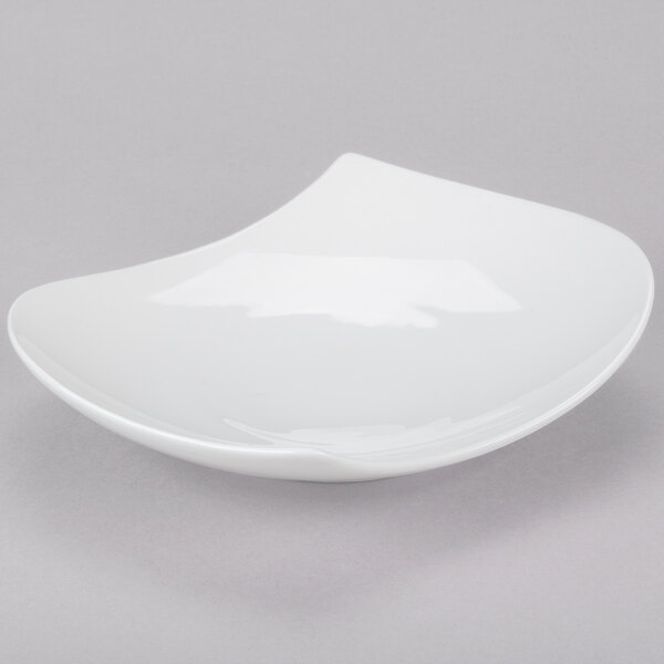 A CAC bone white porcelain peach plate with a curved edge.