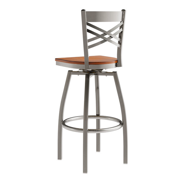 A Lancaster Table & Seating clear coat finish cross back swivel bar stool with a wooden seat.