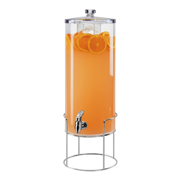 A Cal-Mil round glass beverage dispenser with an infusion chamber and chrome wire base filled with orange liquid.