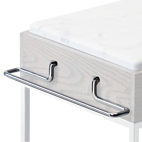 Chrome shelf brackets on a white marble counter top with silver handles.