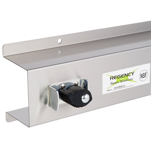 A stainless steel rack with three holders for mops and brooms.