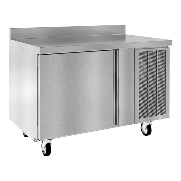 A stainless steel worktop refrigerator with two doors, ventilation grilles, and caster wheels.