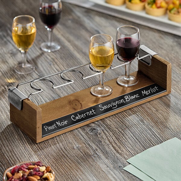 A Cal-Mil wine tasting flight set on a table with a glass of red wine.