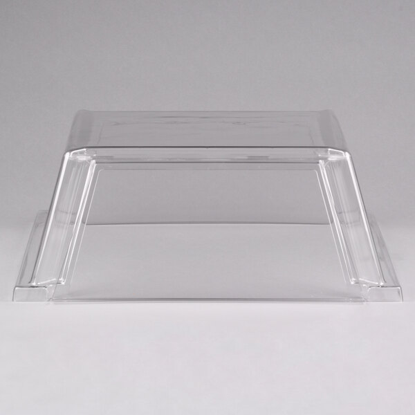 A clear plastic sneeze guard on a white table over a Star Grill Max roller grill.