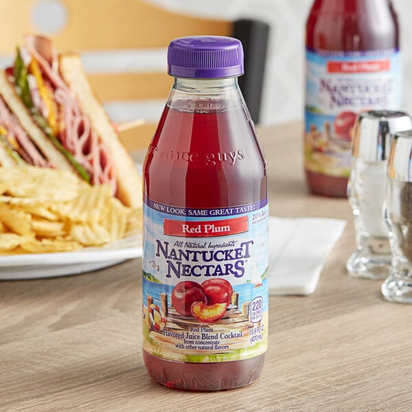 A close-up of a Nantucket Nectars Red Plum Juice bottle on a table.