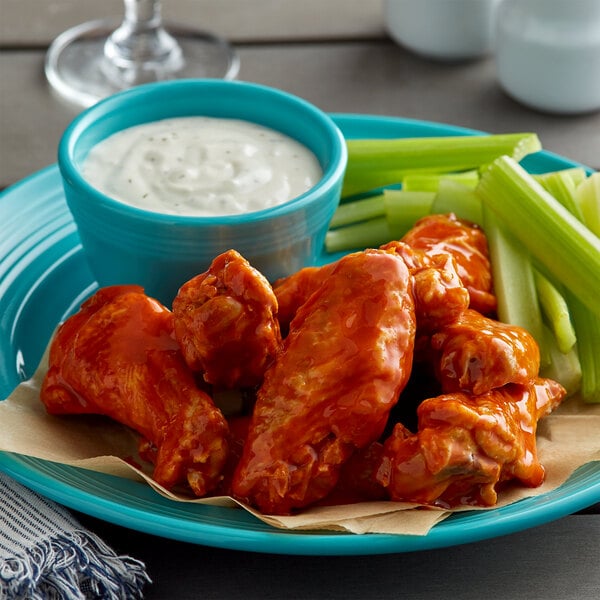 buffalo chicken wings on blue plate with ranch and celery