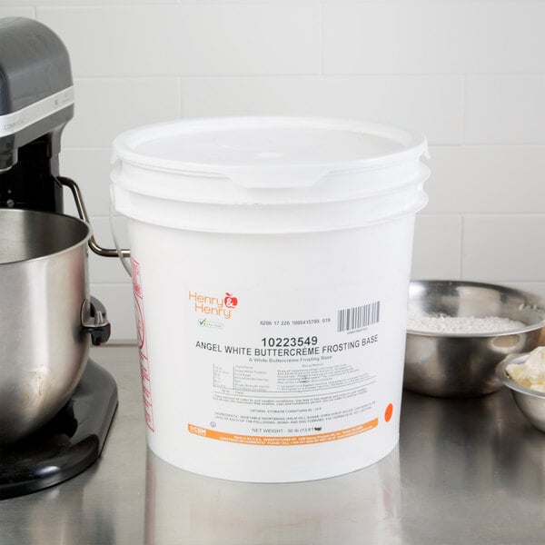 A white bucket with a Henry & Henry label next to bowls of flour and a mixer.