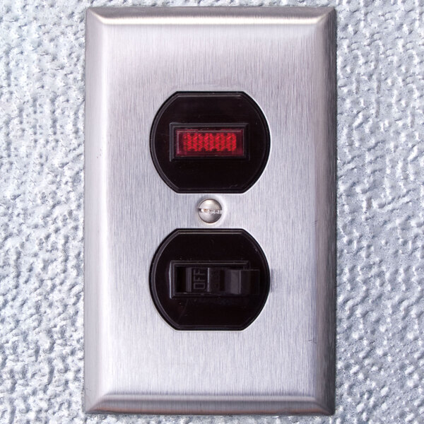 A close-up of a metal switch with red and black numbers on a white wall.