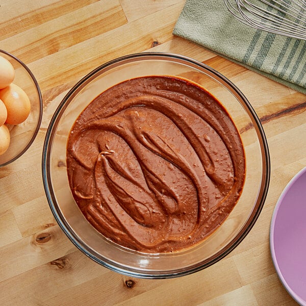 A bowl of brown liquid and eggs on a table.