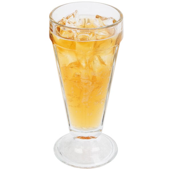 A Libbey soda glass filled with yellow liquid and ice.