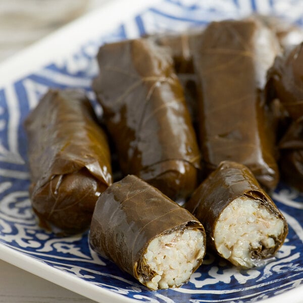 A plate of Stuffed Grape Leaves on a wood surface.