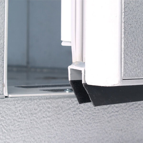 The right hinged metal door of a Kolpak walk-in freezer with a black handle.