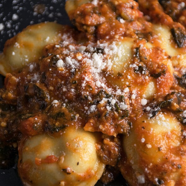 A plate of pasta with sauce and Cucina Andolina grated Parmesan cheese.