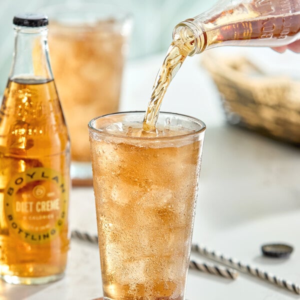 A glass of iced diet creme soda being poured from a bottle, with another bottle of Boylan Bottling Co. Diet Creme Soda nearby.