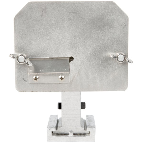 A metal plate with a hole in it on a metal box with a latch on top.