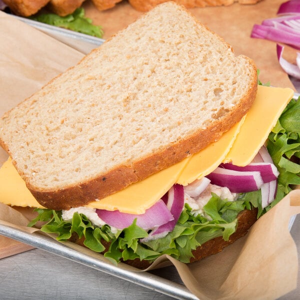 A sandwich with Cooper sharp yellow American cheese and lettuce on a tray.