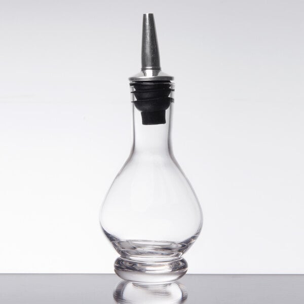 An American Metalcraft clear glass bitters bottle with a metal top.